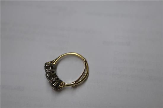 A yellow metal and three stone diamond ring, size H.